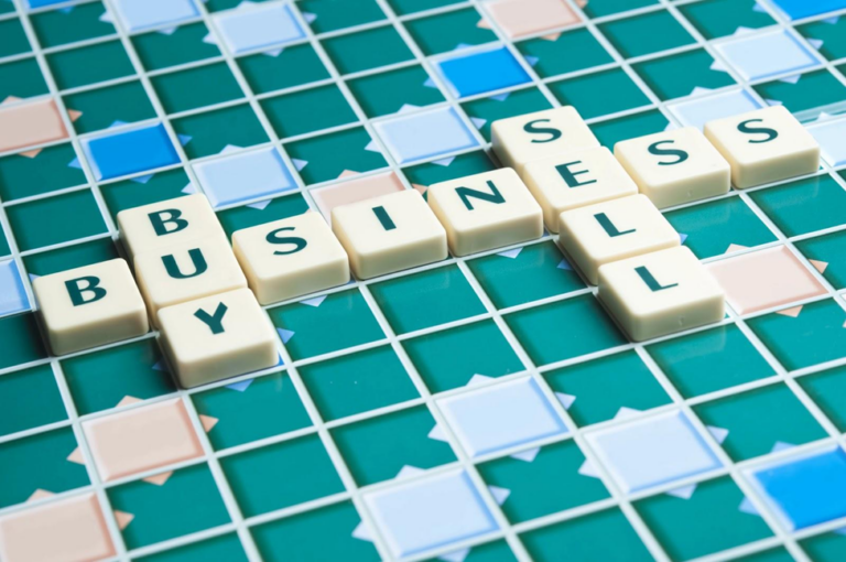 A word board game with letter tiles spelling out the words business, buy, and sell. Choosing the right time to exit your business requires strategy, just as winning a word game does.